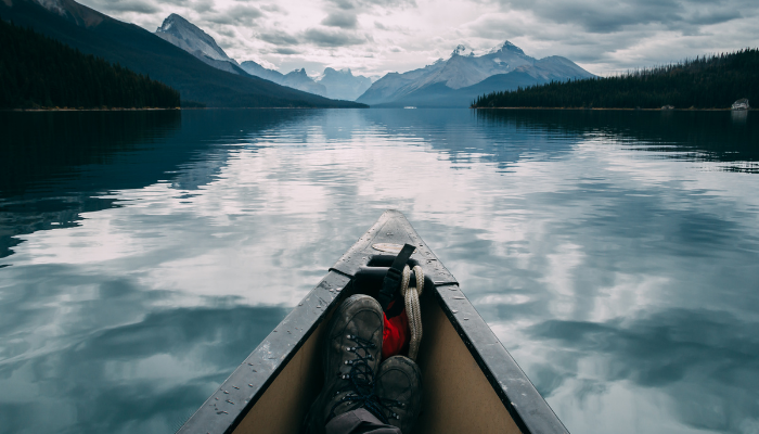 Person in canoe on lake in mountains