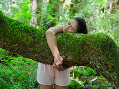 Young girl hugging tree